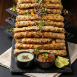 Food Forest Catering artisanal chicken seekh kabab platter on slate board with mint chutney tomato salsa and lemon