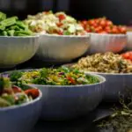 Fresh salad buffet spread with multiple bowls of colourful vegetables and mixed salads at catering event